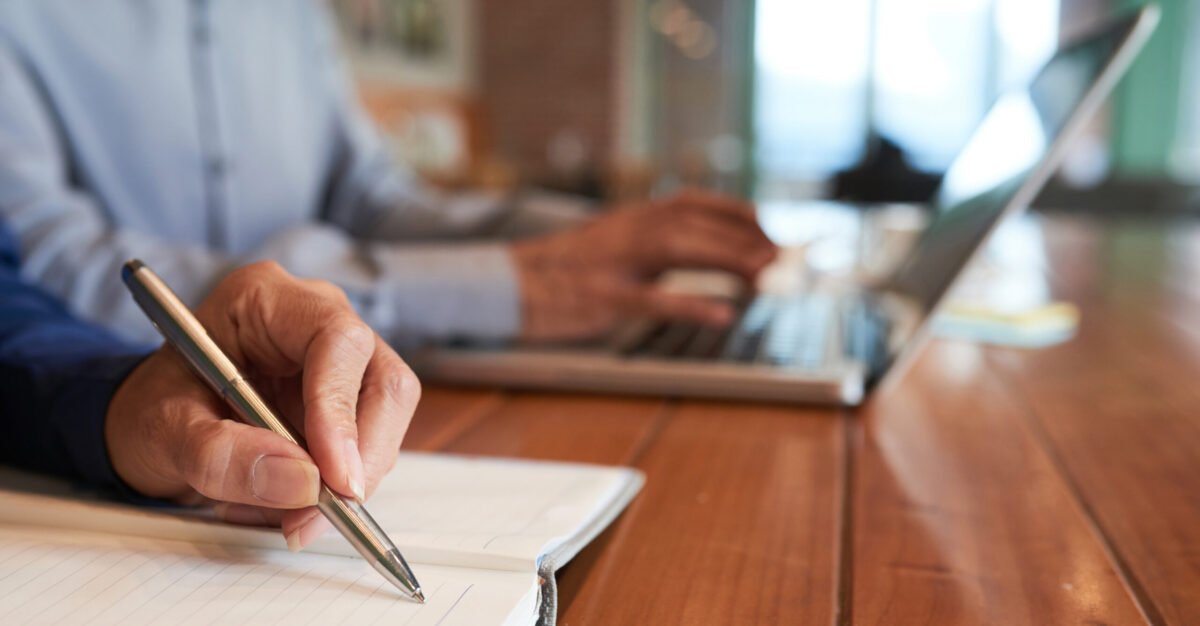 Close-up image of business lady writing plans and ideas in her notepad